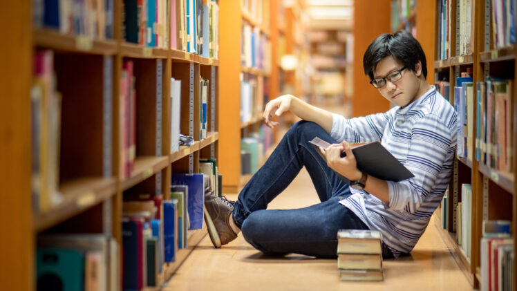 photo of college student reading in library