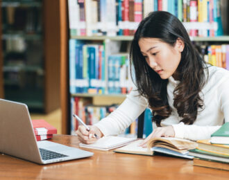 photo of college student studying in a library