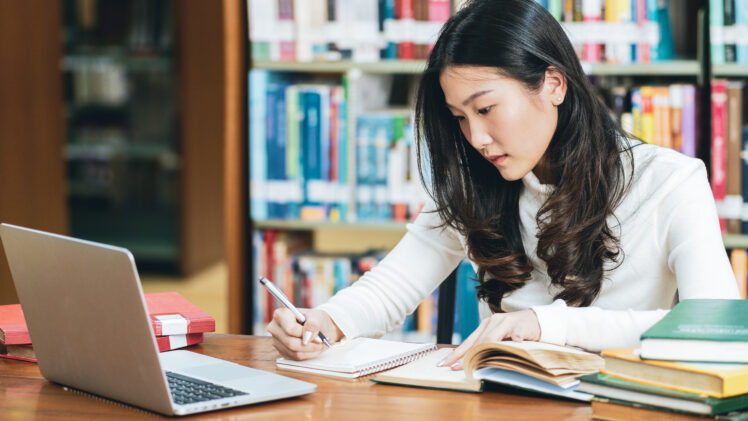 photo of college student studying in a library